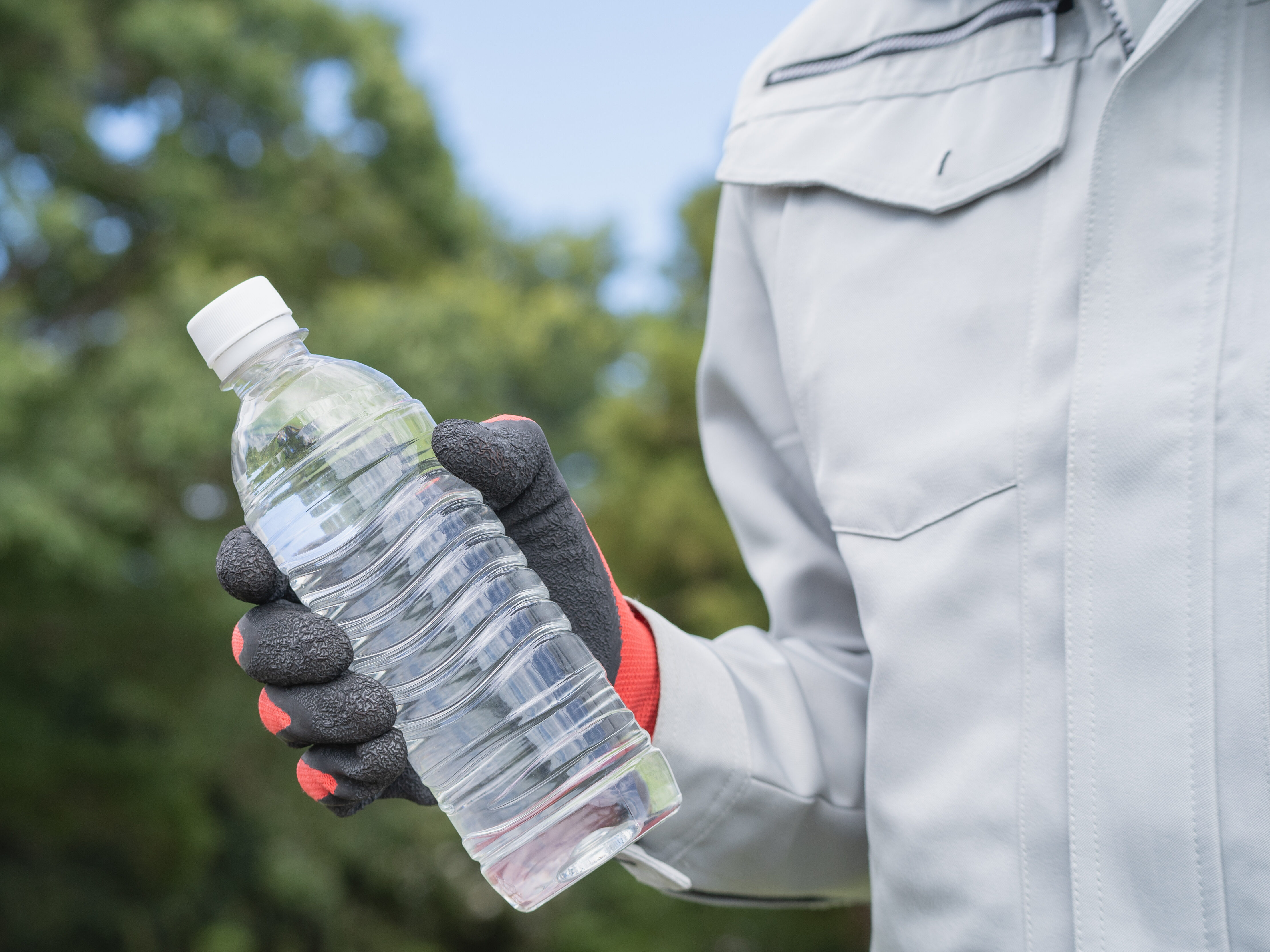 作業服の男性とペットボトルの水|建設業・熱中症対策 イメージ
